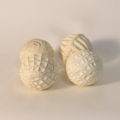 Decorative carved spheres in beige finish with textured patterns for table decor or shelf styling modern home placement white background.