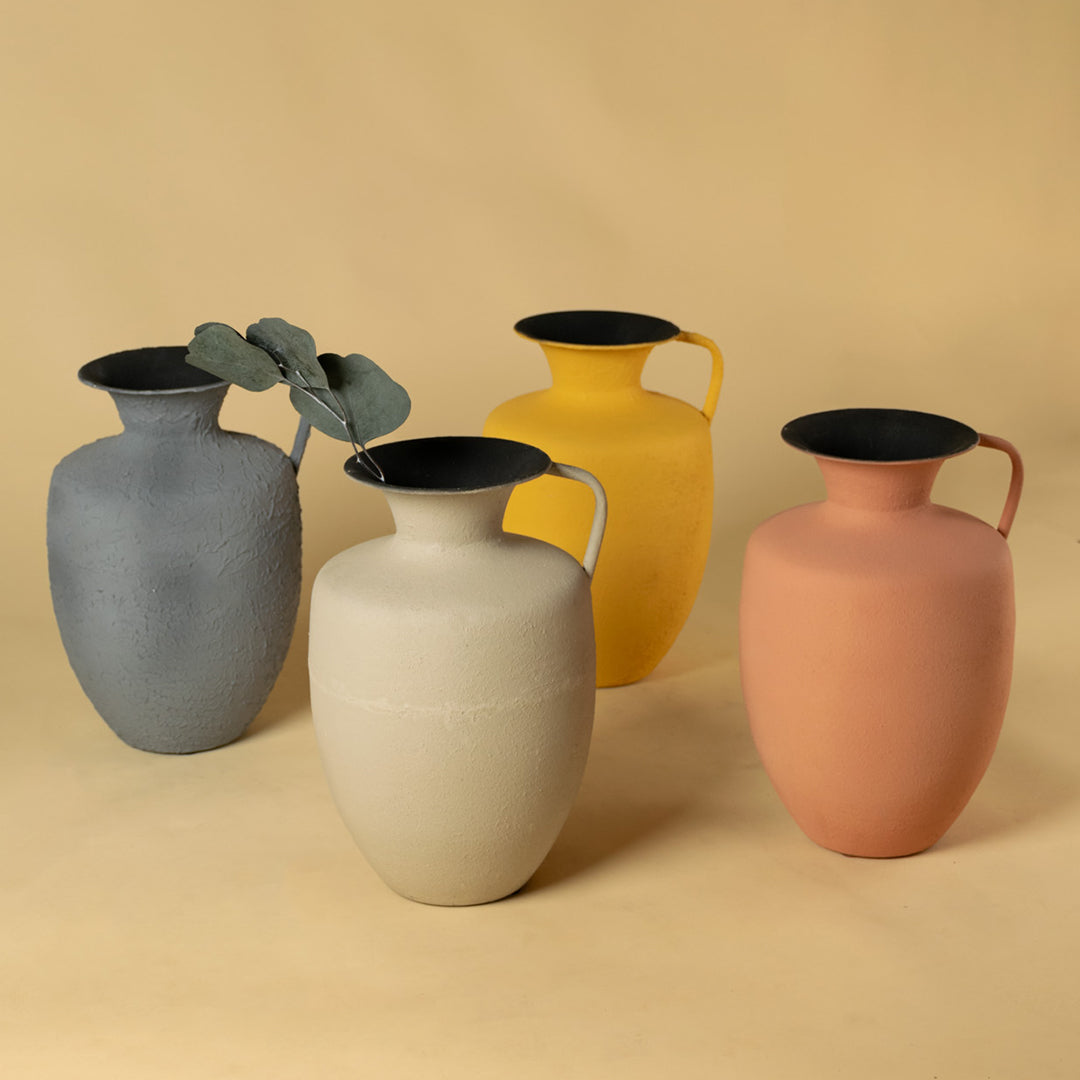 Set of four elegant matte metal pitcher vases in diverse tones for luxury home decor and contemporary interior styling.