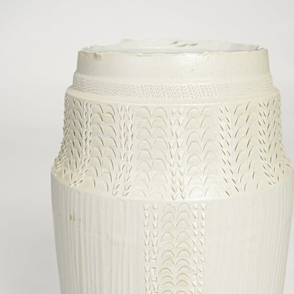 Close view of white ceramic textured vase featuring intricate surface pattern and elegant handcrafted detailing.
