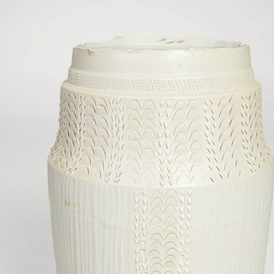 Close view of white ceramic textured vase featuring intricate surface pattern and elegant handcrafted detailing.