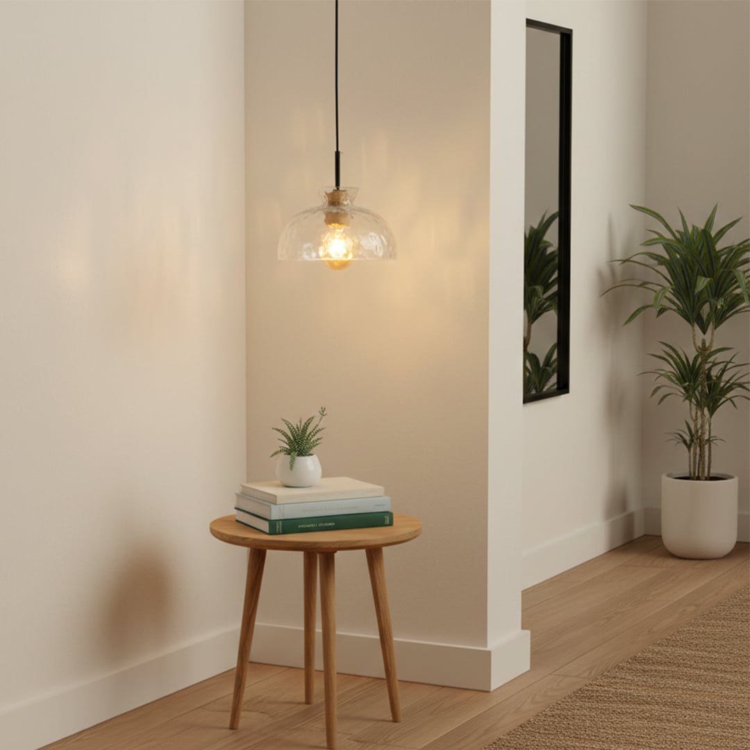 Clear glass and brass metal pendant light creating warm ambience in modern hallway interiors.