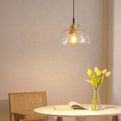 Clear textured glass and brass metal pendant light creating cozy ambience in modern dining interiors.