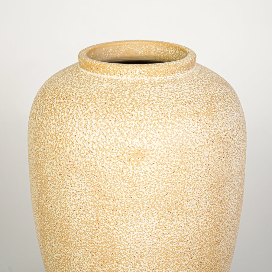 Closeup image of beige ceramic decorative vase for modern interior decor styling with textured matte finish.