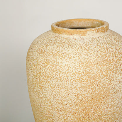Closeup image of beige ceramic decorative vase for modern tabletop decor styling with rustic textured finish.
