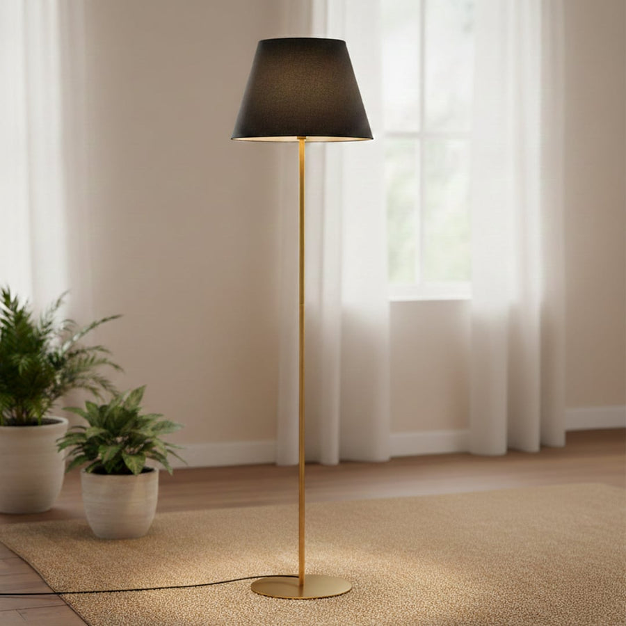 Modern gold metal floor lamp with black fabric shade placed in living room corner for warm ambient lighting Decor.