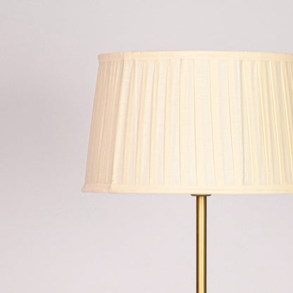 Pleated white fabric lampshade with soft textured folds and classic drum shape design detail.