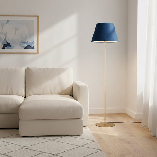 Modern gold metal floor lamp with blue fabric shade placed beside sofa in elegant living space for soft ambient lighting Decor.