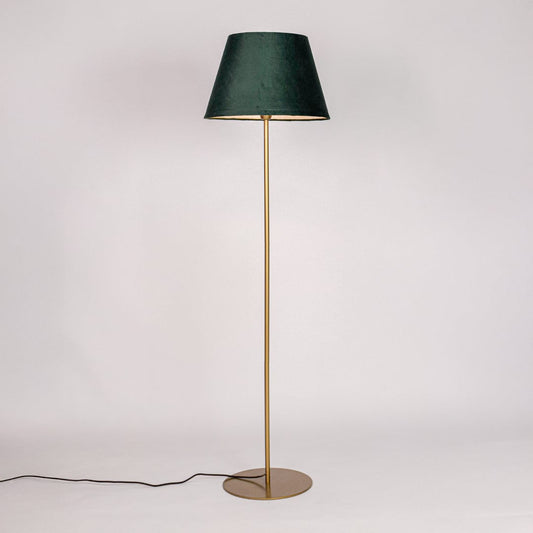 Gold metal floor lamp with green fabric shade illuminated on white background for warm ambient home lighting Decor.