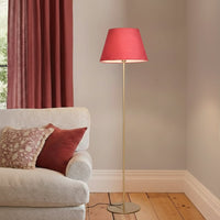 Modern gold metal floor lamp with red fabric shade placed near sofa in cozy living room corner for warm accent lighting Decor.