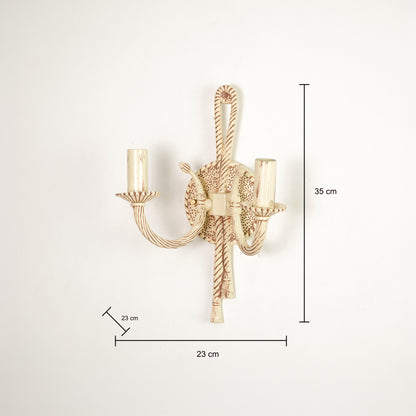 A wall-mounted two-light candle-style sconce in a warm gold finish, shown with dimension lines and labels indicating a height of 35 cm, width of 23 cm, and candle-tip spacing of 23 cm against a plain white background.