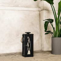 Modern black metal outdoor lantern with clear glass panels enhancing contemporary patio and garden decor with candlelight.