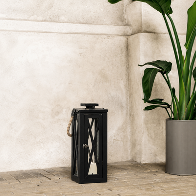 Modern black metal outdoor lantern with clear glass panels enhancing contemporary patio and garden decor with candlelight.