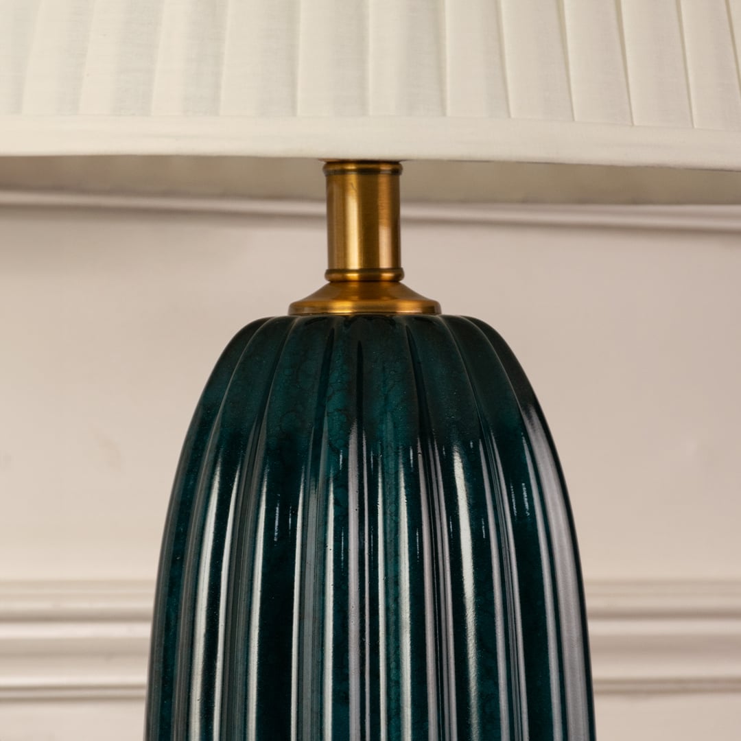 Blue ribbed glass lamp base with brass detailing showcasing refined craftsmanship and sophisticated decorative appeal.
