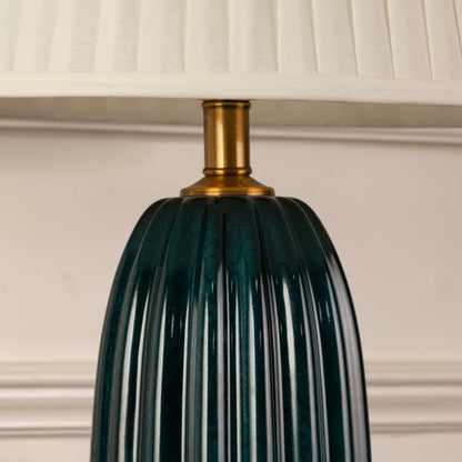 Blue ribbed glass lamp base with brass detailing showcasing refined craftsmanship and sophisticated decorative appeal.