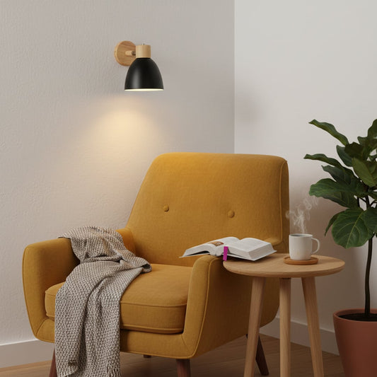 Modern wall light with black metal shade and wooden mount placed above lounge chair creating warm reading corner lighting for living room decor.