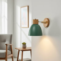 Modern green metal wall light with wooden accents for stylish bedroom and Scandinavian home decor spaces.