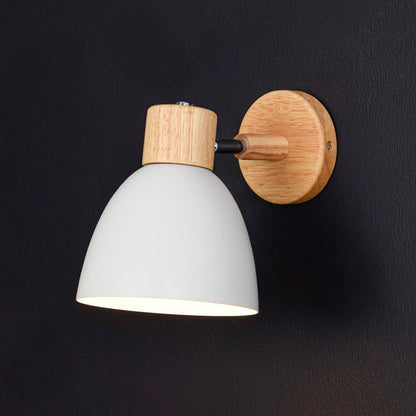 White wall light with wooden mount illuminated on dark wall adding warmth and soft contrast to modern decor.