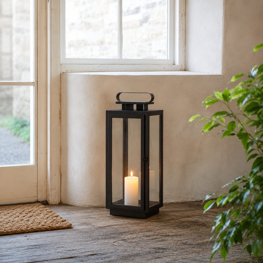 Minimalist black metal glass floor candle lantern for house indoor entryway porch steps and contemporary home decor styling.