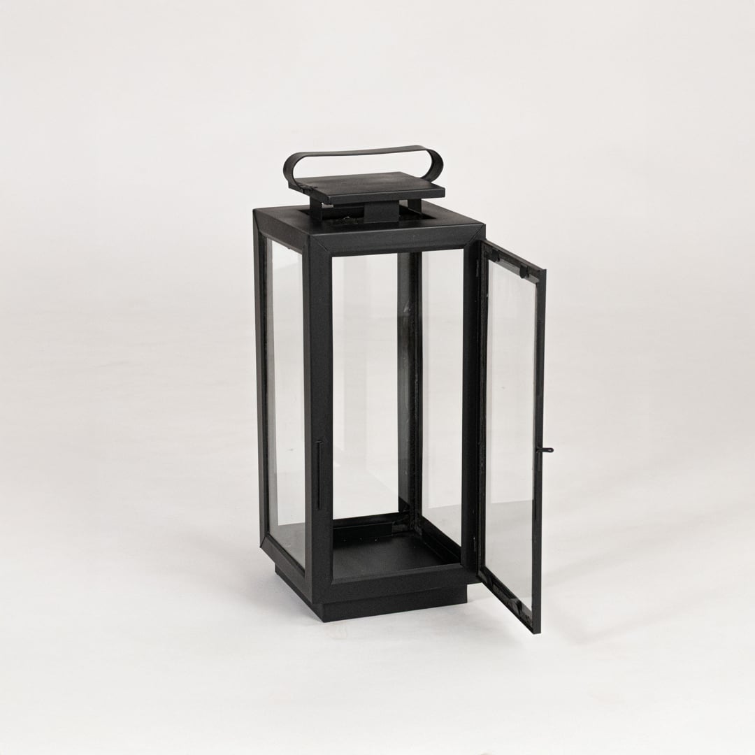 Modern black metal lantern with glass panels on white background suitable for living room balcony and patio Decor.