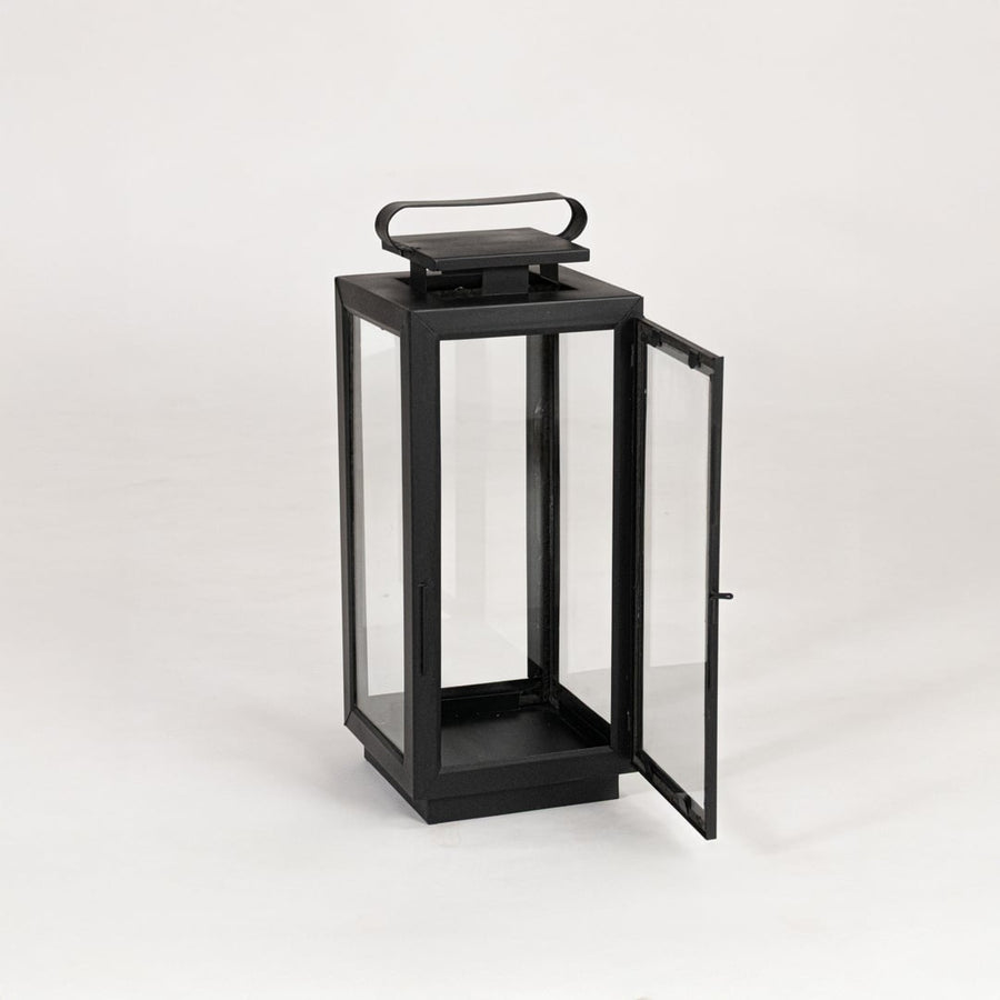 Modern black metal lantern with glass panels on white background suitable for living room balcony and patio Decor.
