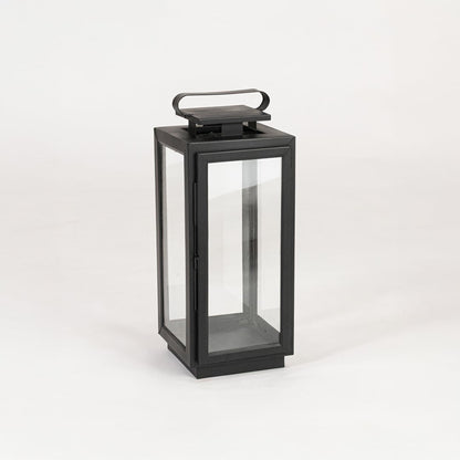 Decorative black metal lantern with clear glass panels on white background designed for tabletop and floor Decor.