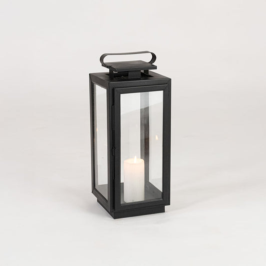 Minimal black metal candle lantern with transparent glass panels on white background perfect for festive home Decor.