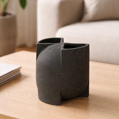 Black ceramic abstract decorative vase displayed on coffee table creating bold and minimalist interior decor accent.