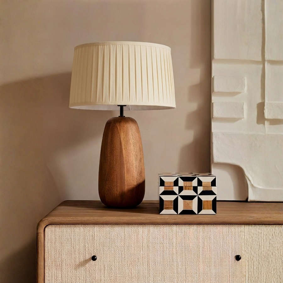 Cream pleated fabric table lamp with wooden base placed on a console table for cozy modern interiors.