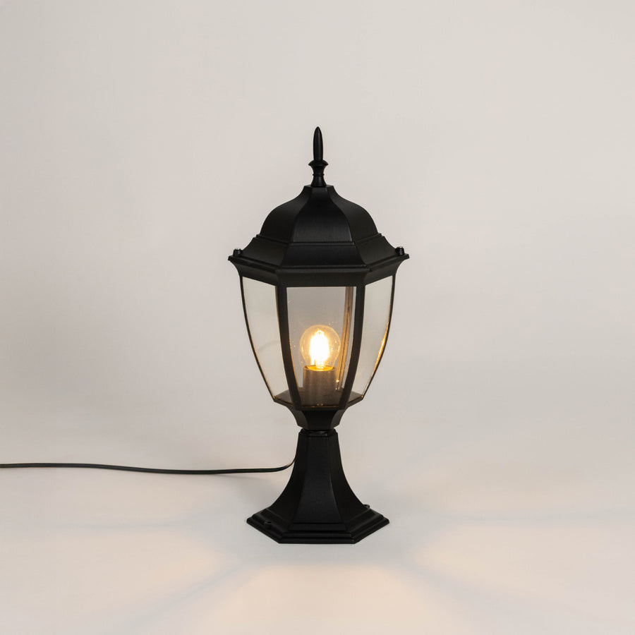 Classic black outdoor gate light with warm glowing bulb for stylish exterior decor styling use.