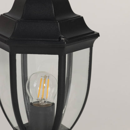 Closeup view of outdoor black pillar lamp showing clear glass design and LED bulb with elegant vintage modern finish.