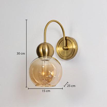 Gold metal wall light with amber glass globe shade shown with 30 cm height and 15 cm width for precise sizing.