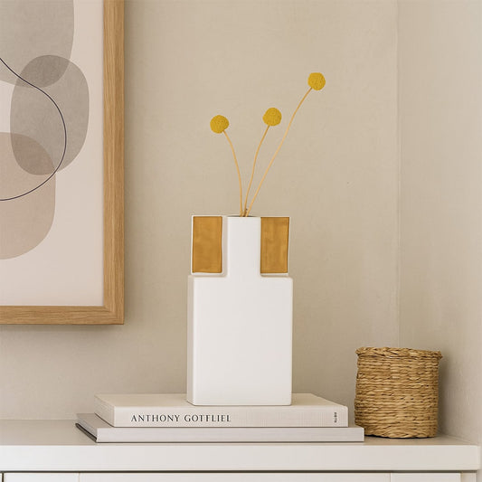 Modern white ceramic vase with gold accents displayed on a clean minimal surface  styled in soft lighting for a refined contemporary look.