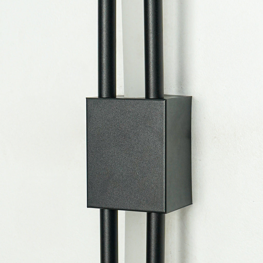 Closeup of textured black metal wall light with sleek dual rods for luxury hallway bedroom and living room interiors.