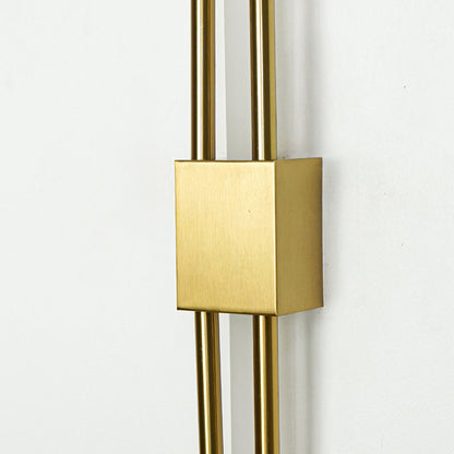 Closeup of brushed gold metal wall light with sleek dual rod design for luxury modern home interior decor.