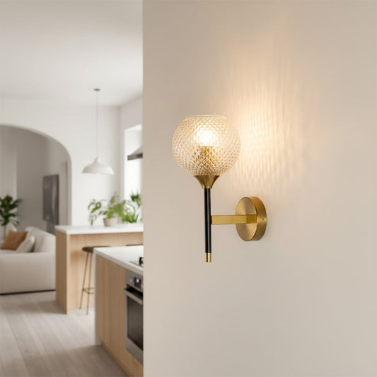 Modern gold metal wall light with textured glass globe for stylish hallway and premium decor spaces.