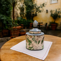 Tropical leaf jar displayed on an outdoor table adding freshness and tropical charm to garden decor.