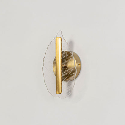 Gold metal and clear glass leaf wall light displayed off on a white background showing its elegant modern home decor finish.
