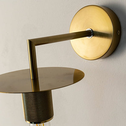Closeup of gold wall light showing fine brushed metal texture and exposed bulb design for a modern lighting look.
