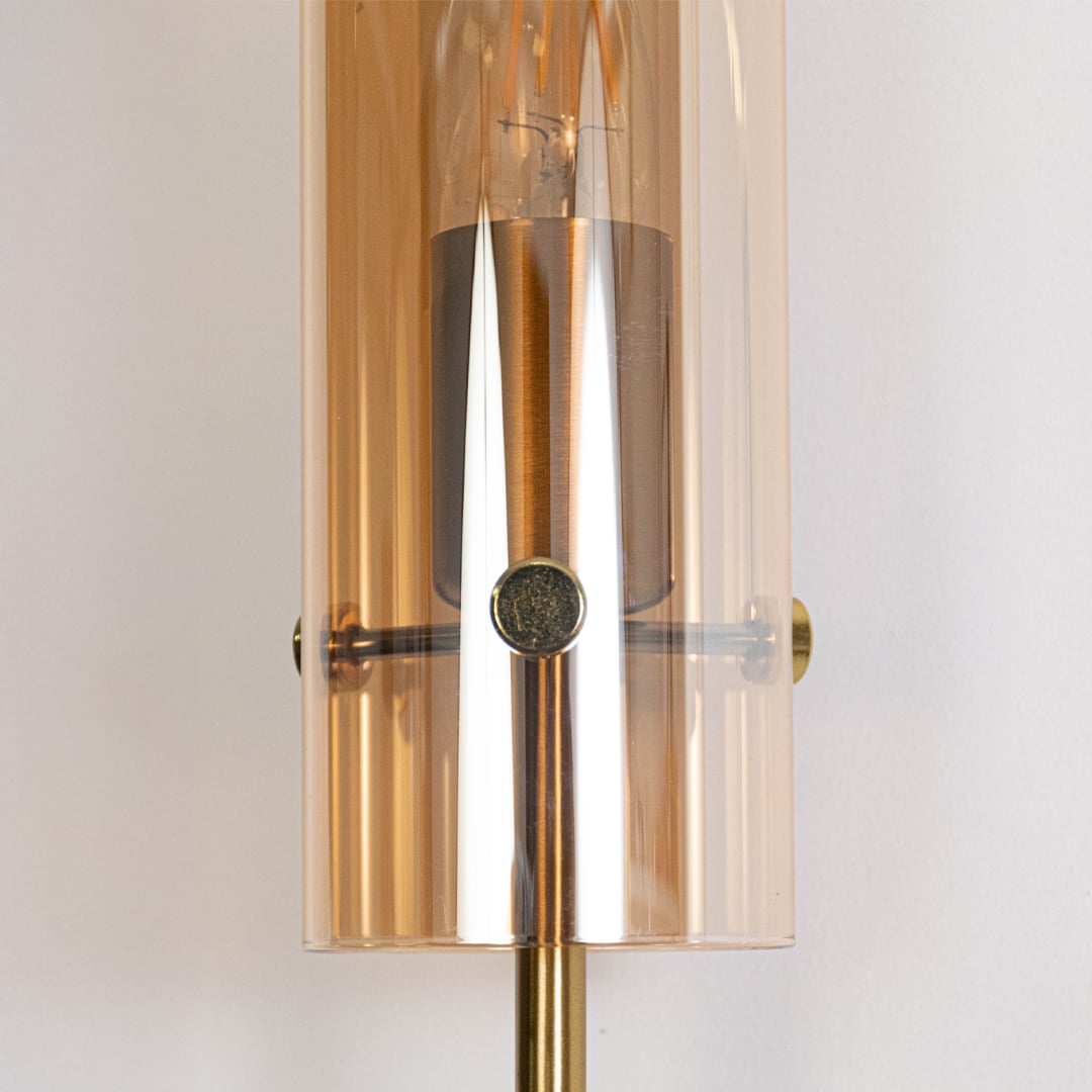 Detailed view of black modern wall sconce with cylindrical glass shade elegant finish ideal for bedroom hallway and living space.
