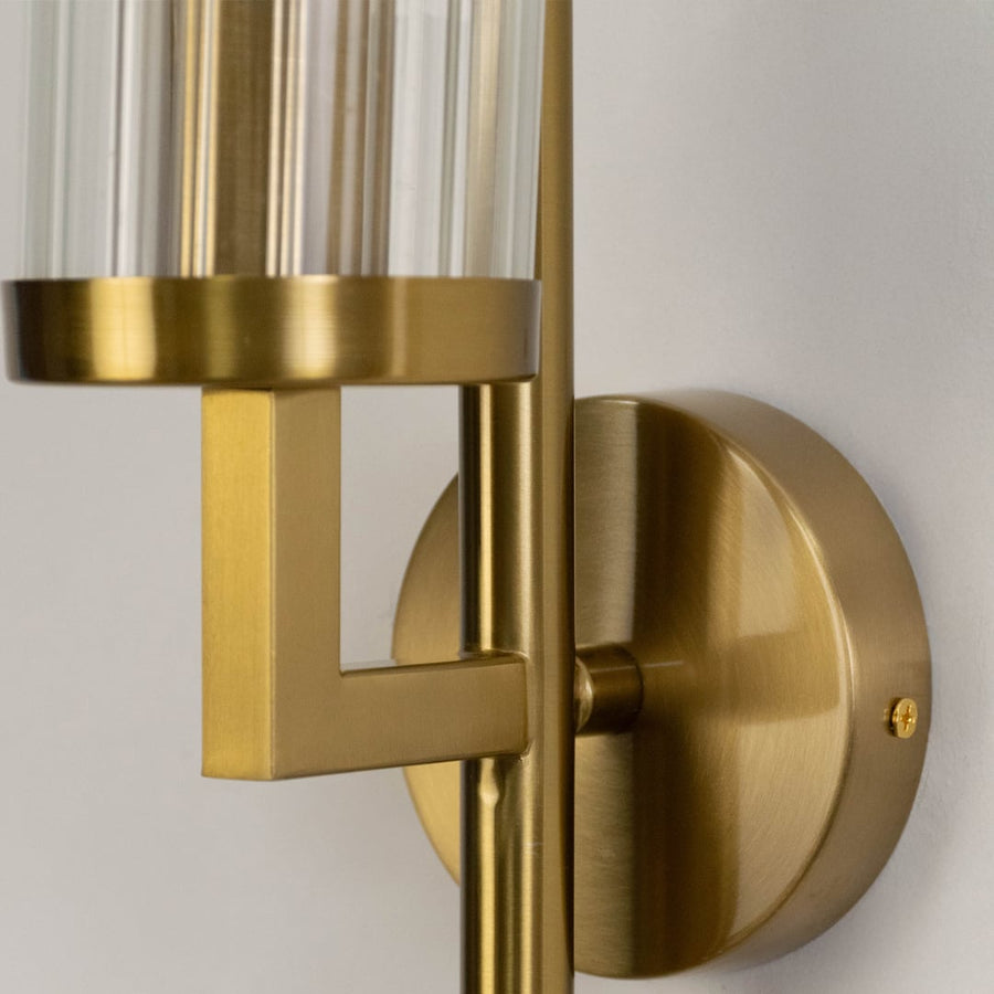 Closeup of luxury gold wall sconce with ribbed glass shade sleek modern design perfect for bedroom hallway and living room.