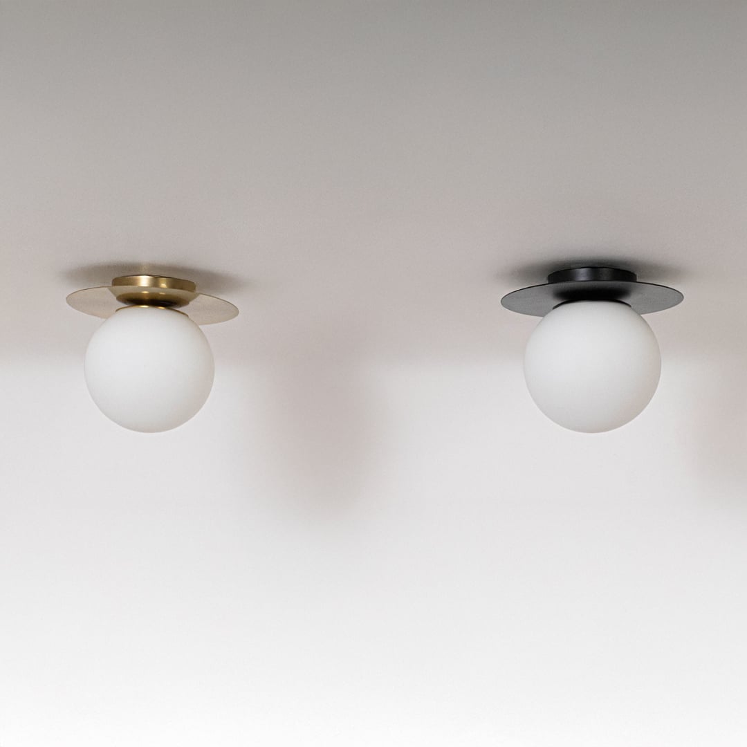 Collection of ceiling lights in black and gold finish with frosted glass globe shades shown off on white background.