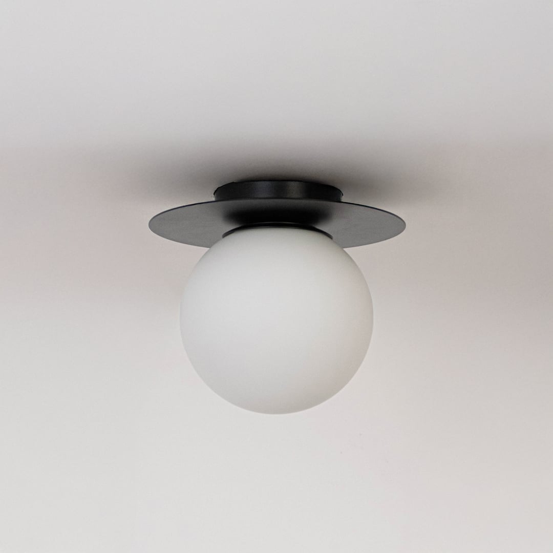 Ceiling light with black finish base and frosted glass globe shade shown switched off on plain white background.