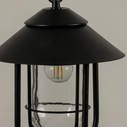 Closeup of an outdoor pendant lantern showing detailed metal curves glass clarity and smooth craftsmanship captured with natural light.