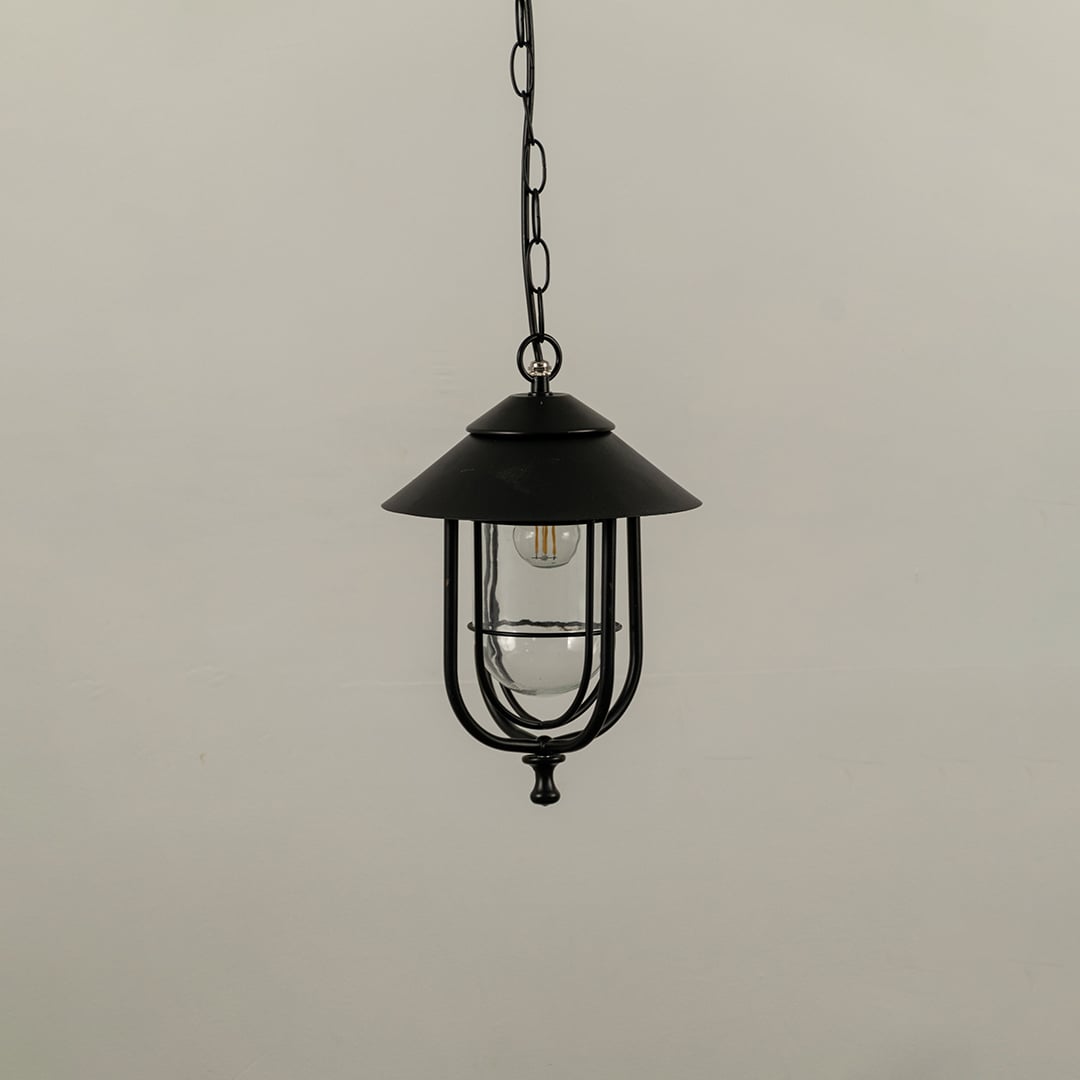 Outdoor hanging lantern with light off shown on a white background featuring a clear glass body and sleek metal frame with smooth detailing.