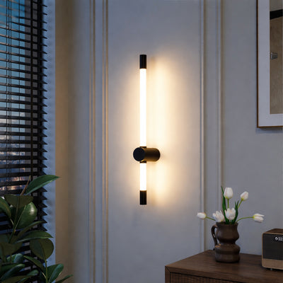 Modern wall light with vertical tube design and black metal mount emitting warm glow ideal for bedroom or living room wall decor.