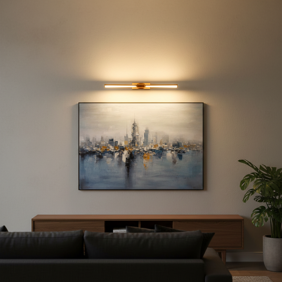 Gold metal picture light casting warm illumination above framed artwork enhancing sophisticated living room interiors.
