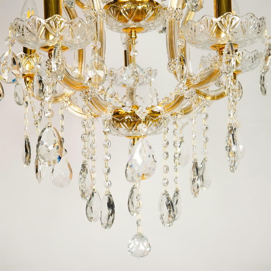 Closeup image of clear glass arm chandelier for luxury living room decor styling with polished glass finish.