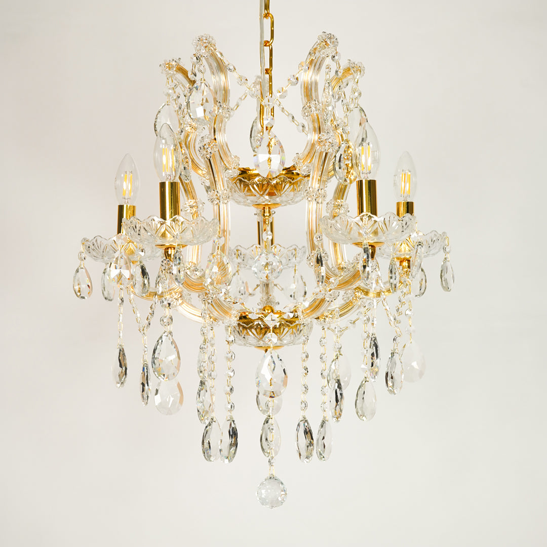 White background image of clear glass arm chandelier for elegant dining room decor styling with unlit glass arms.