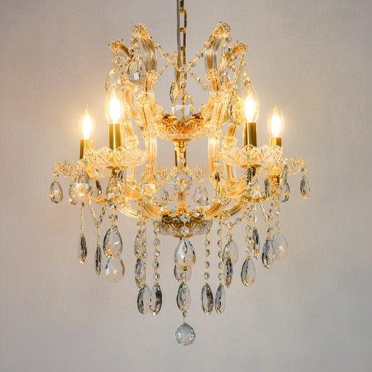 White background image of clear glass arm chandelier for modern living room decor styling with a bright warm glow.