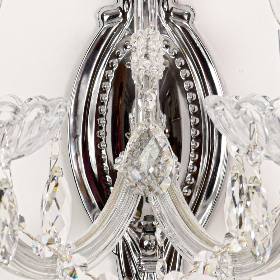 Closeup of silver crystal wall light with faceted crystal drops and curved arms perfect for luxury wall decor.